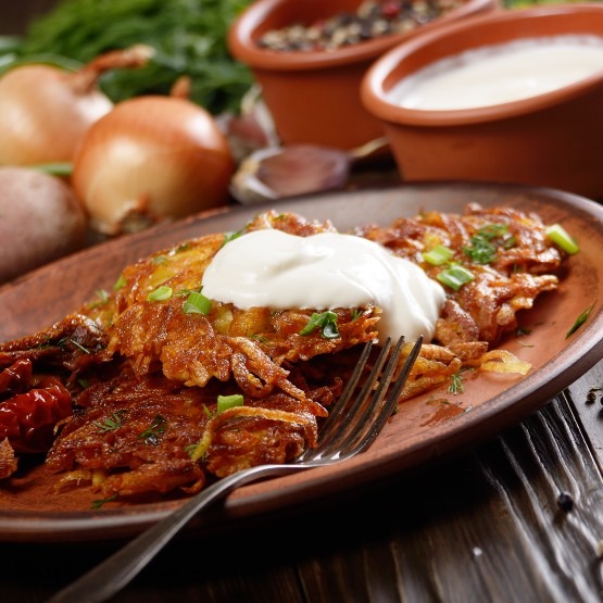homemade-tasty-potato-pancakes-in-clay-dish-with-s-2023-11-27-05-12-58-utc